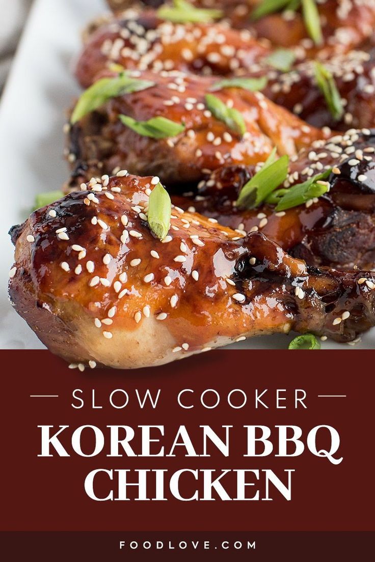 slow cooker korean bbq chicken on a white plate with sesame seeds and garnishes