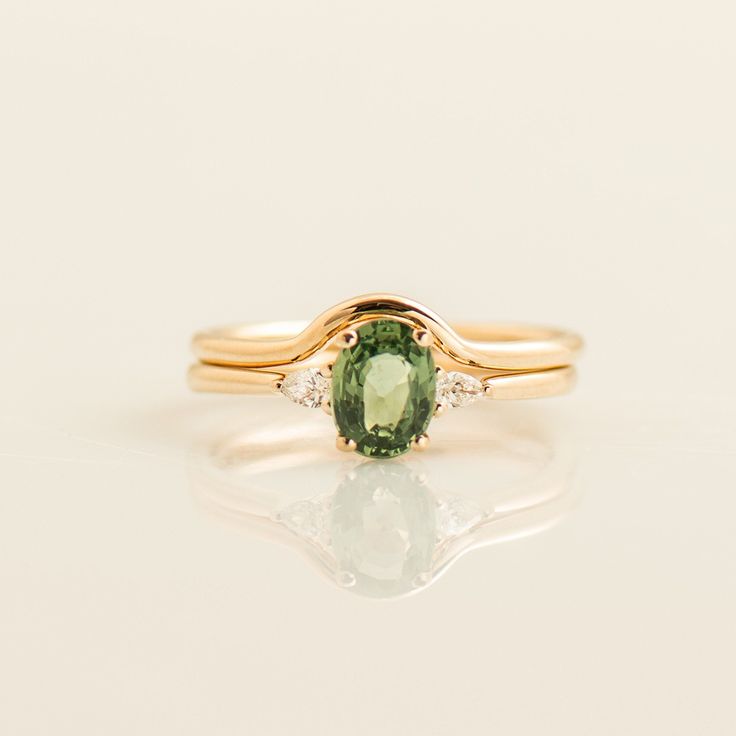 The green sapphire ring set, made in 14k or 18k rose gold, features the iconic green sapphire ring and a plain, curved matching ring ✶ This listing is for the green sapphire engagement ring & the matching gold band. the sapphire ring is a low setting which makes it delicate on the hand, yet with lots of presence. The center oval stone is a natural sapphire in high-quality. This listing is for ROSE GOLD. You can order other colors at the following links: ● Yellow gold - www.etsy.com/listing/1770963377 ● White gold - www.etsy.com/listing/1772141065 You can order each ring separately at the following links: ● Green Sapphire Engagement Ring - www.etsy.com/listing/1362275619 ● Matching Wedding Band - www.etsy.com/listing/1772173151 ♦ CENTER GEMSTONE SPECIFICATIONS ♦  Type: Light Green Sapphire Green 14k Gold Promise Ring, Heirloom Green Sapphire Ring For Wedding, Heirloom Green Sapphire Wedding Ring, Fine Jewelry 14k Gold Green Sapphire Ring, Fine Jewelry Green Sapphire Ring With Rose Cut Diamonds, Green Sapphire Ring With Rose Cut Diamonds, Green Sapphire Ring In 14k Gold For Wedding, Green Sapphire Wedding Ring Fine Jewelry, Green Rose Cut Diamonds Fine Jewelry For Wedding