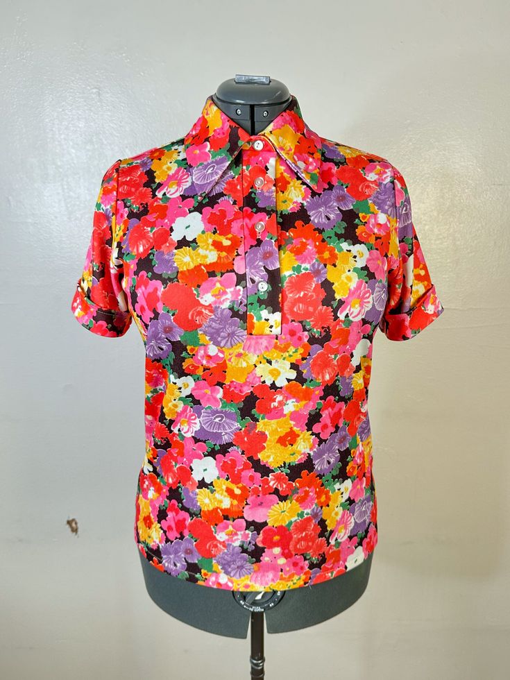 1960s 70s Floral Blouse 40" Bust Quarter button down front Pointed collar  Mock cuffed sleeves  Stretchy polyester material Shoulder to shoulder: 14.5" Bust: 40" - 44" Waist: 38" 44" Around hem: 40" - 42" Length: 24" Cuff: 12" - 15" round No labels/Polyester materials/stretchy Condition/Flaws: Overall great condition, a few spots where the seam stitching is loose and unraveling but not a huge impact on wearing, tiny little gray mark under seam of button down part Retro Spring Tops With Johnny Collar, Retro Collared Blouse For Vintage Fashion, Fitted Collared Tops Inspired By 70s, Fitted Vintage Tops With Placket, Retro Collared Blouse With Buttons, Retro Collared Top With Placket, Fitted Collared 70s Inspired Tops, Collared Retro Blouse With Retro Print, 70s Inspired Fitted Collared Tops