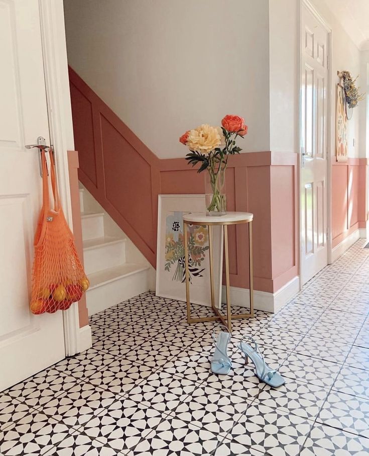 a vase with flowers sitting on top of a table next to a pair of shoes