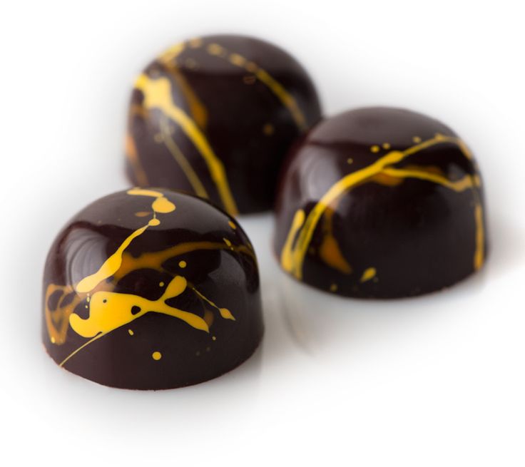 three pieces of chocolate with yellow paint on them