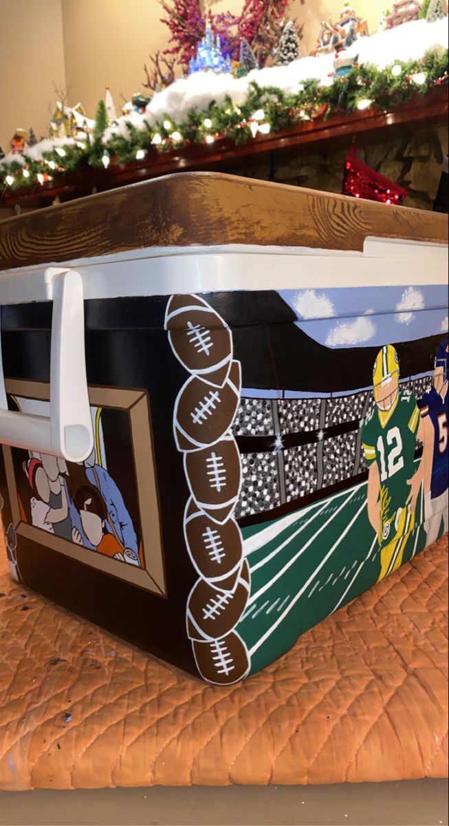 a football themed cooler sitting on top of a bed