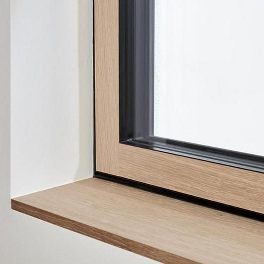 an open window on the side of a white wall with wood trim and black frame