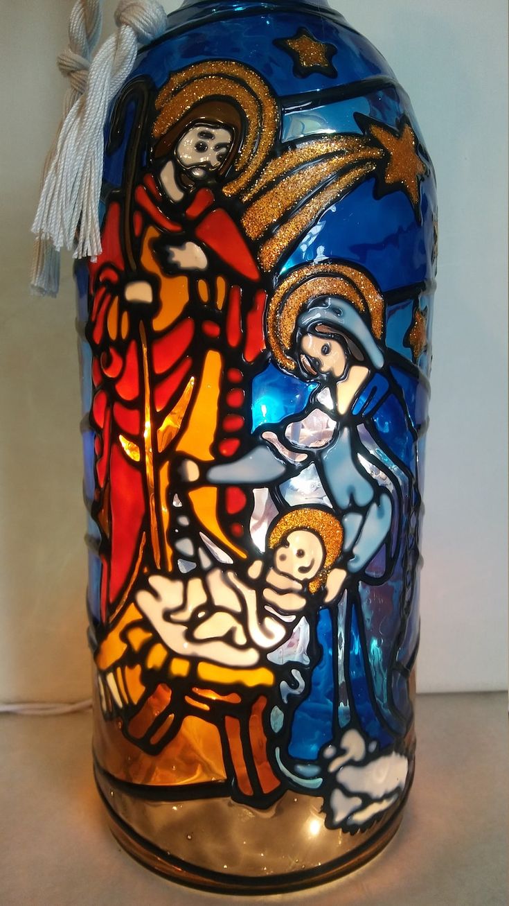 a blue glass vase with an image of the birth of jesus