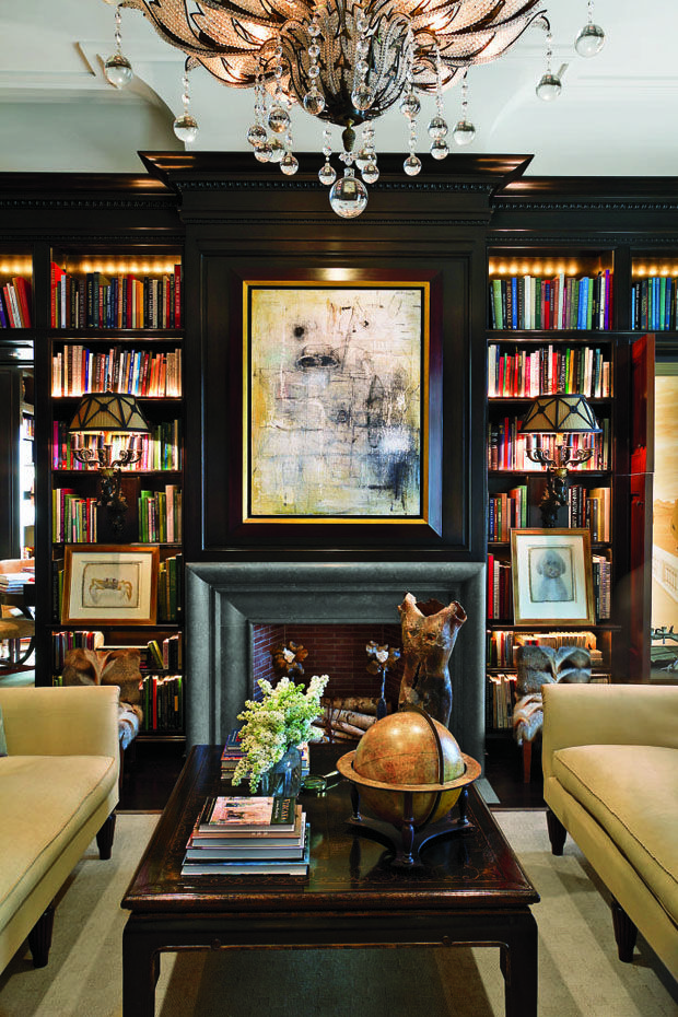 a living room filled with lots of furniture and a fire place under a chandelier