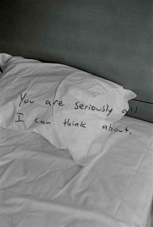 an unmade bed with writing on it