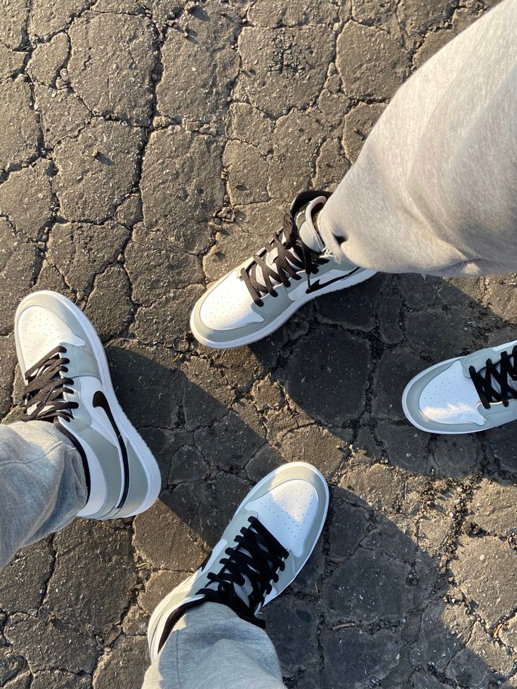 two people standing next to each other wearing white and black shoes