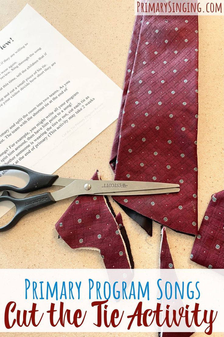 a pair of scissors sitting on top of a piece of fabric next to a piece of paper