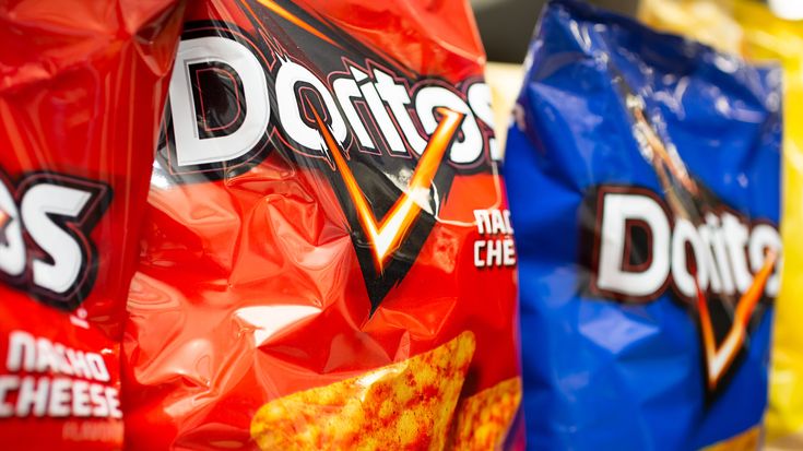 bags of doritos are lined up on the shelf