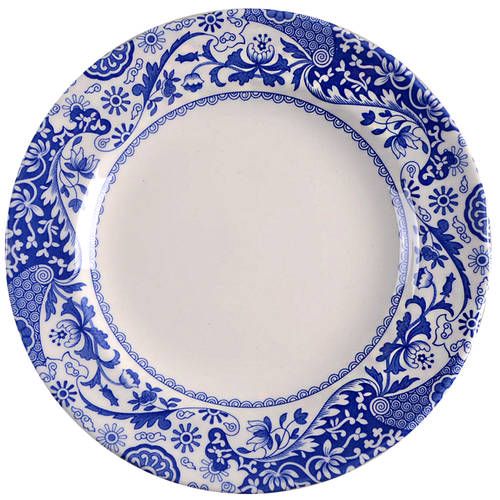 a blue and white plate with an ornate design on the rim, set against a white background