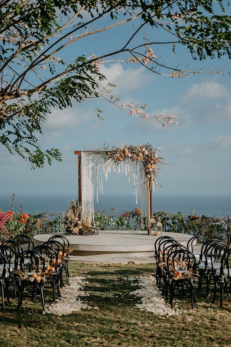 an outdoor ceremony set up with chairs and flowers