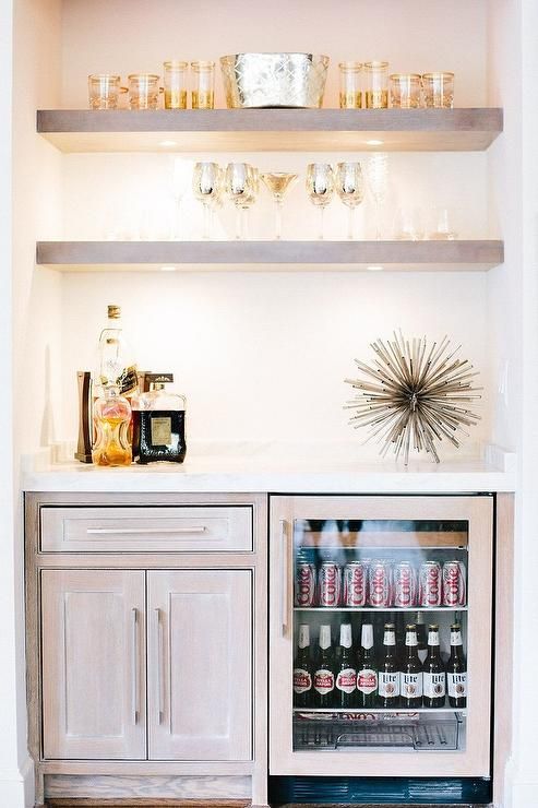 a beverage cooler sitting in the corner of a room with pictures on the wall above it