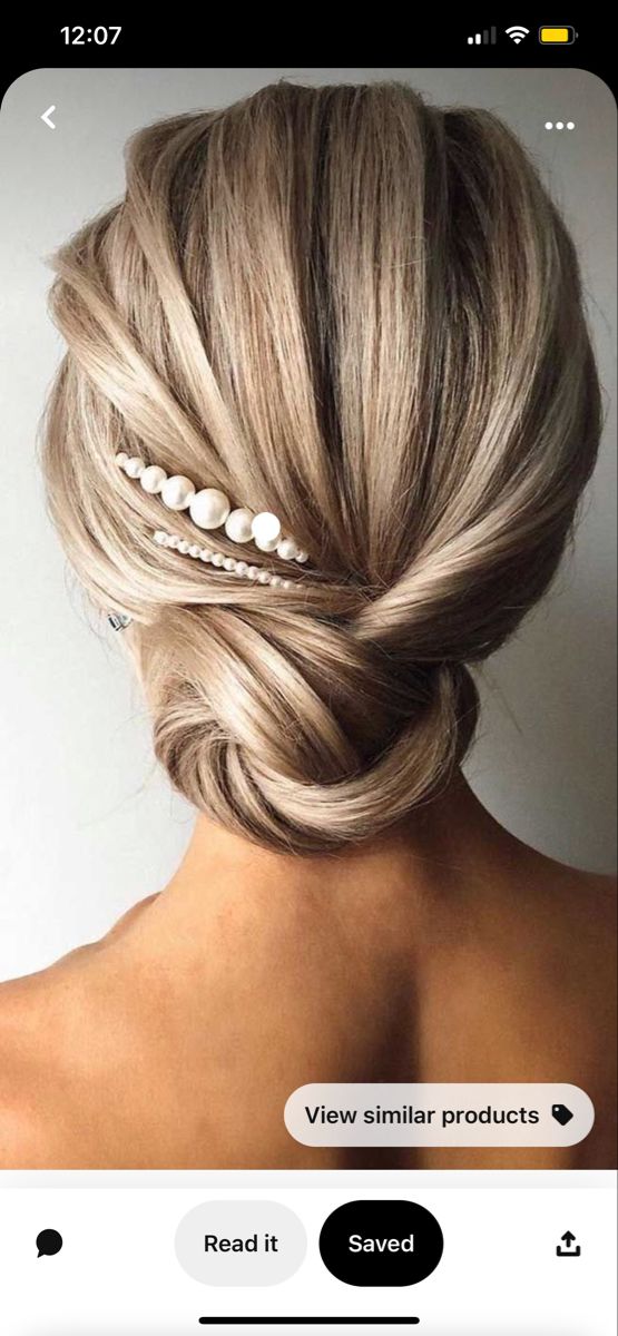 the back of a woman's head with her hair styled in a low bun