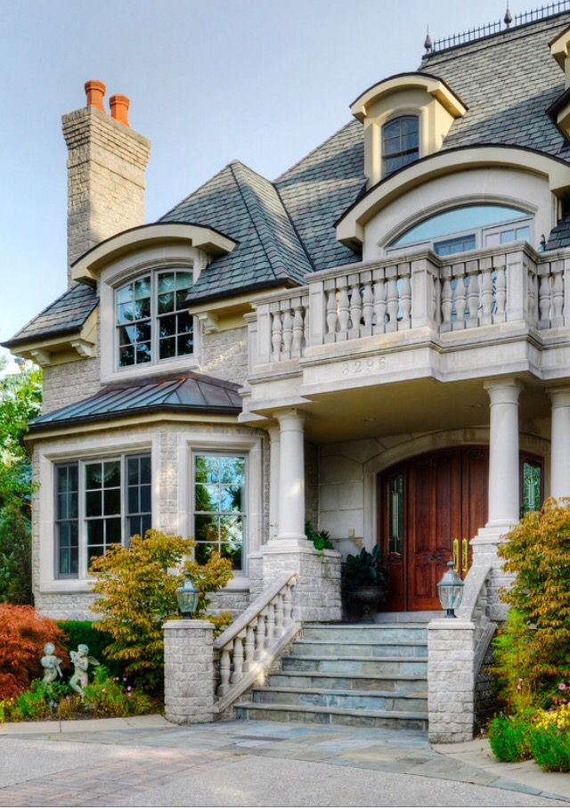 a large house with steps leading up to the front door and two story entryway