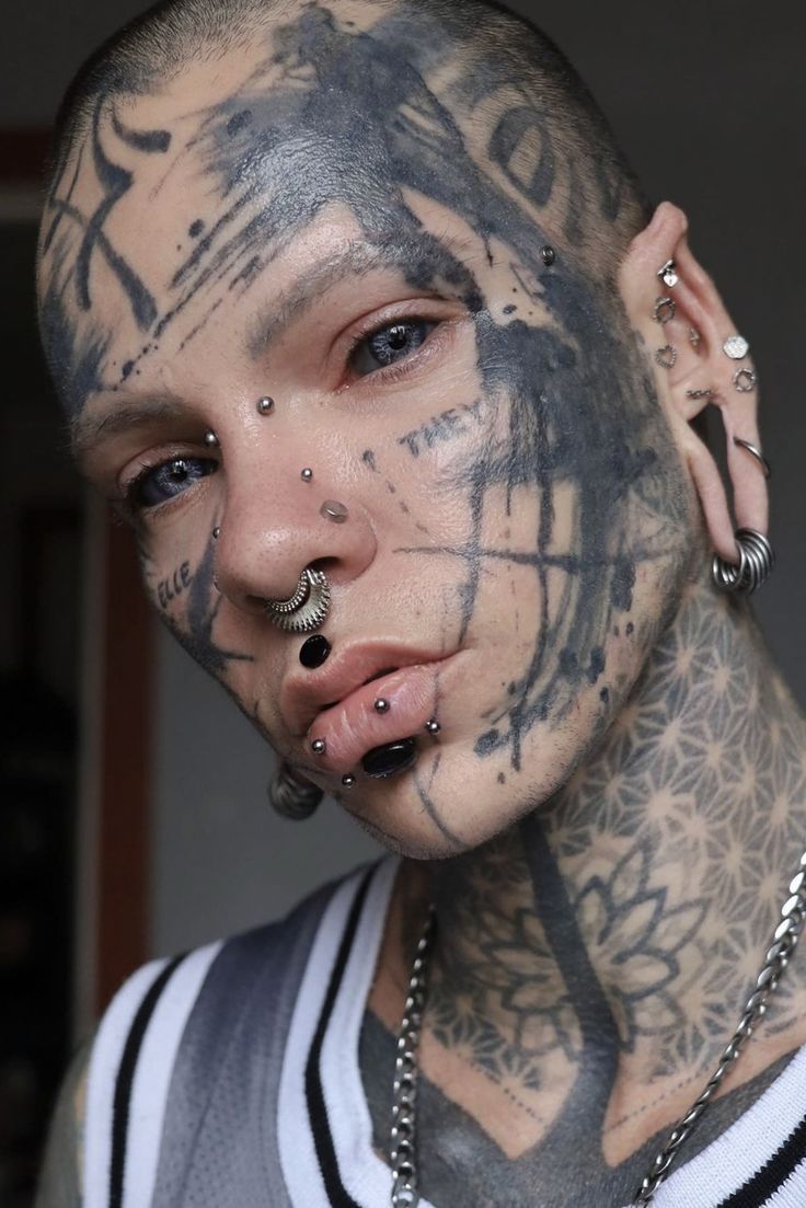 a man with tattoos and piercings on his face