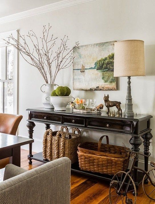 a living room filled with furniture next to a table covered in baskets and vases