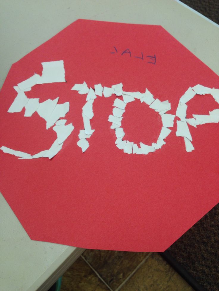 a red stop sign that has been cut out with white paper and some writing on it