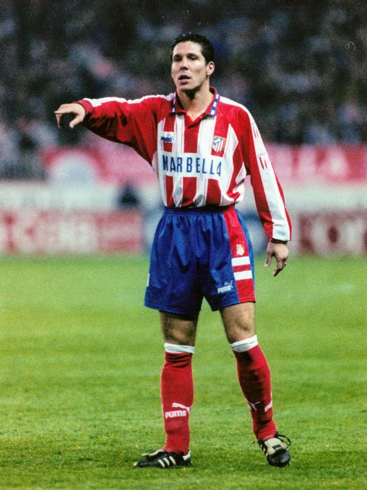 a soccer player is pointing at something on the field with his hand out to him