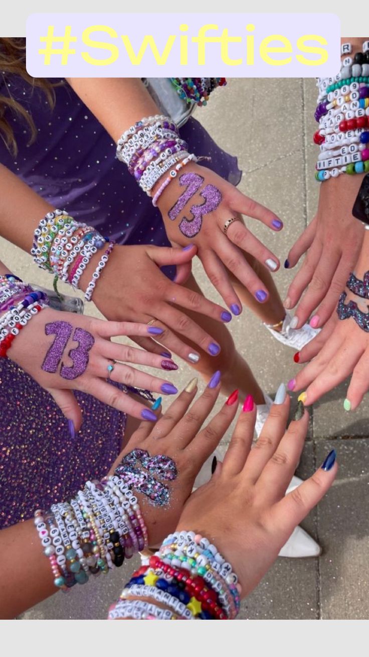 a group of people with their hands together and numbers painted on the nails in different colors