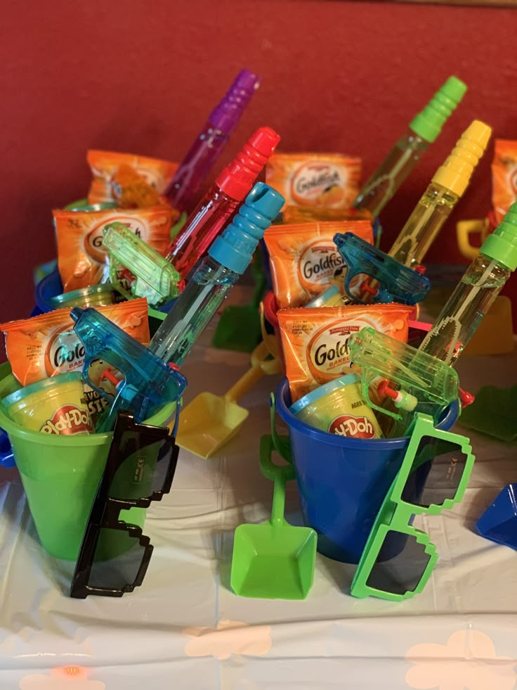 there are many toothbrushes in the buckets on the table with candy bars