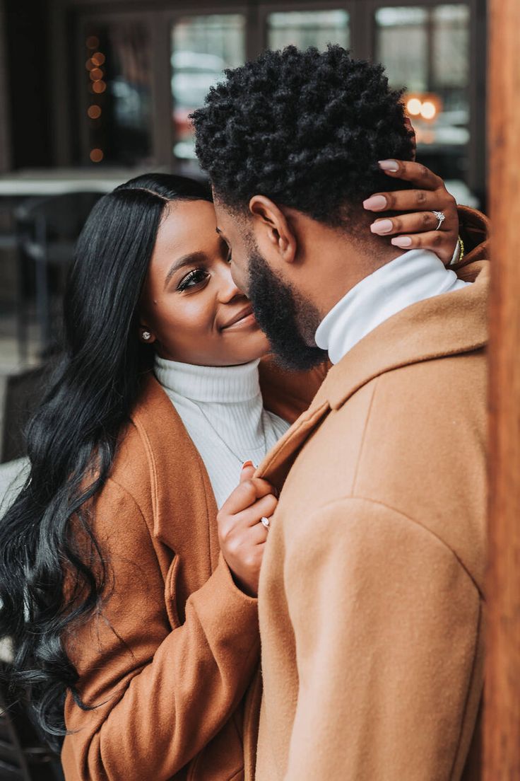 a man and woman embracing each other in front of a building