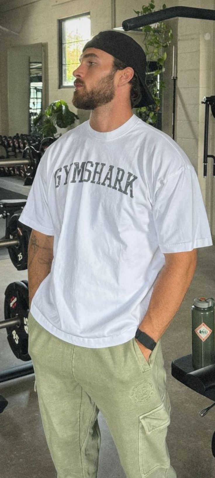 a man standing in a gym with his hands on his hips and looking off to the side