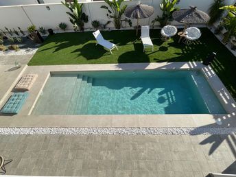 an aerial view of a pool and patio area