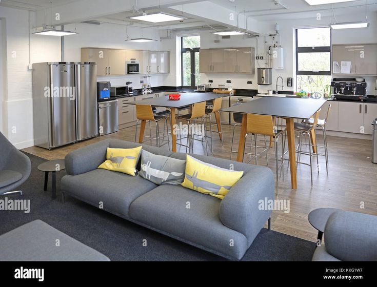 an open concept kitchen and living room in a modern home with wood flooring, stainless steel