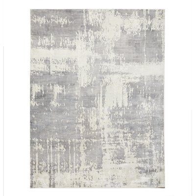 a gray and white rug with an abstract design