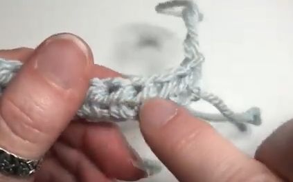 someone is crocheting an object with yarn