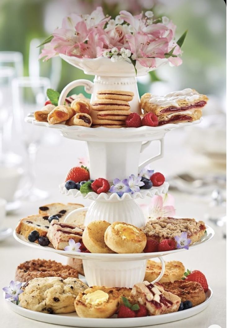 three tiered trays filled with different types of pastries and desserts on top of each other