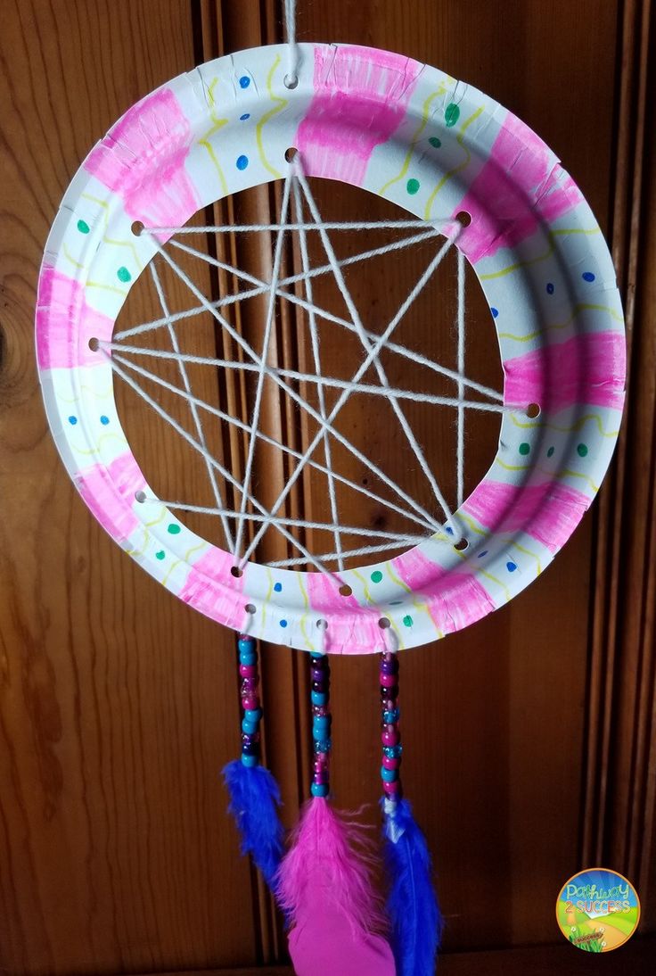 a paper plate dream catcher hanging from a door