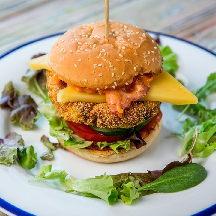 a chicken sandwich on a plate with lettuce and tomato