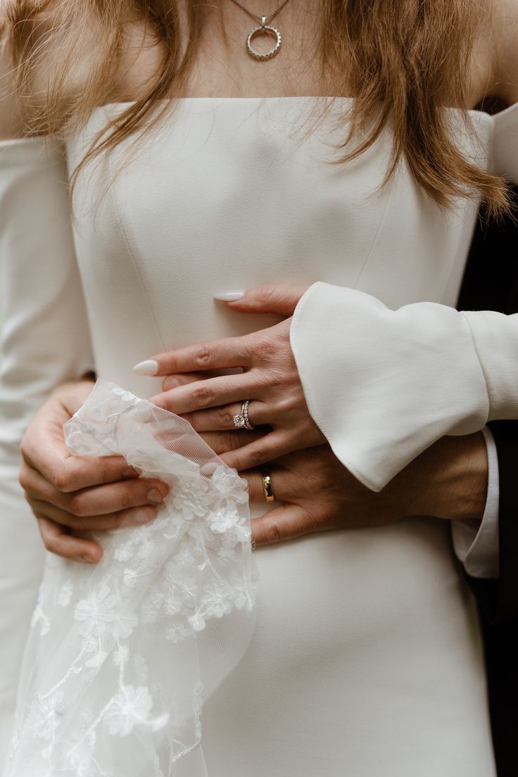 a close up of a person wearing a white dress and holding something in their hands