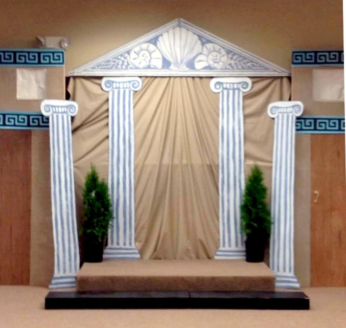 a stage set up for an event with columns and pillars