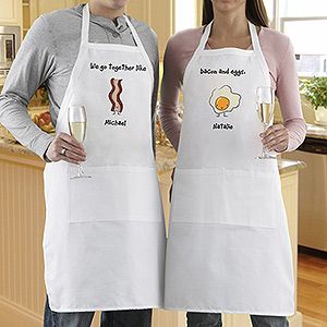 two people wearing aprons holding wine glasses