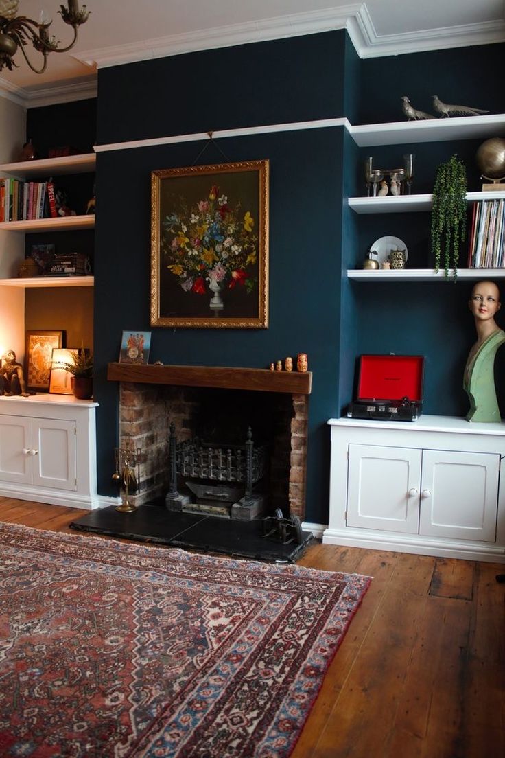 a living room filled with furniture and a fire place next to a book shelf on top of a hard wood floor