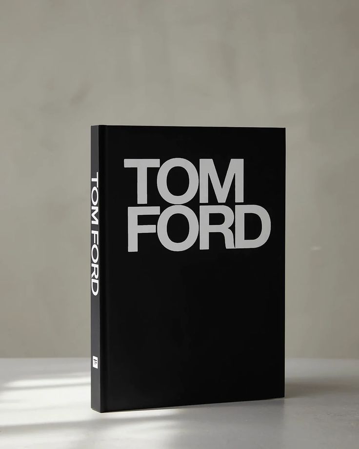 a book with the title tom ford written in white on black cover sitting on a table