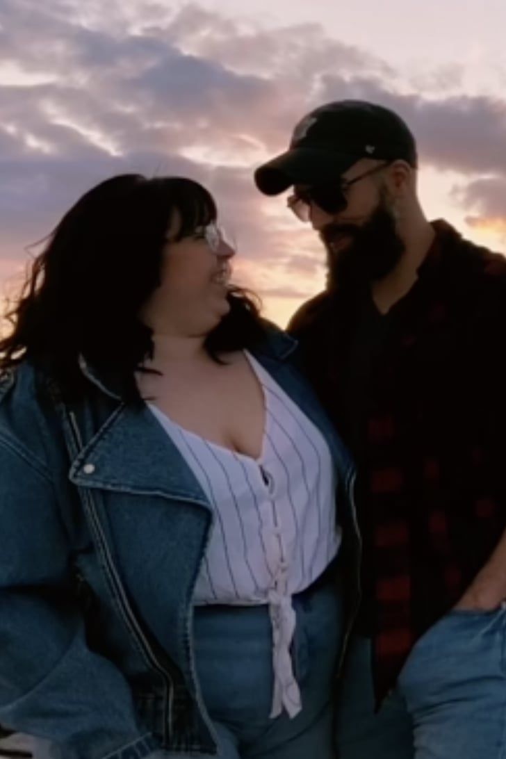 a man and woman standing next to each other in front of the sky at sunset