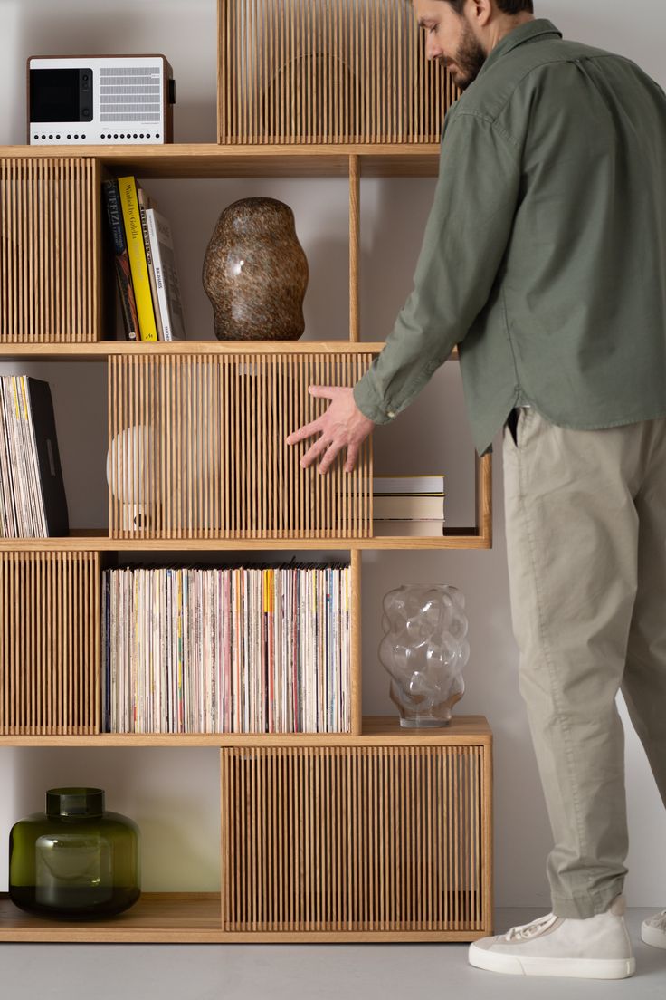 a man standing in front of a book shelf