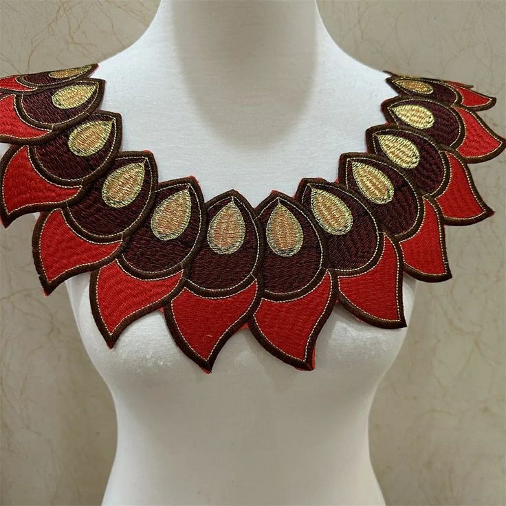 a white mannequin with a red and brown necklace on it