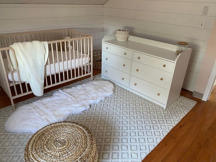 a white crib and dresser in a room