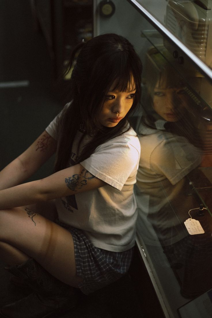 a woman sitting on the ground in front of an oven with her legs crossed and hands behind her back