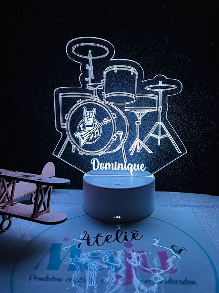 the illuminated drum set is on display in front of a table with a toy car