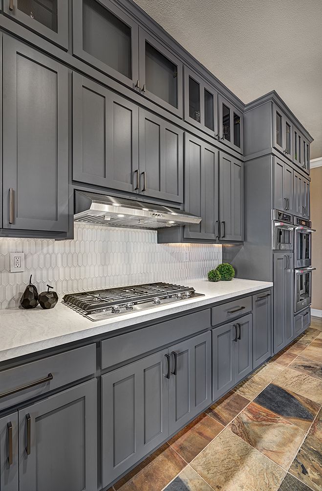 a kitchen with gray cabinets and white counter tops is seen in this image from the front view