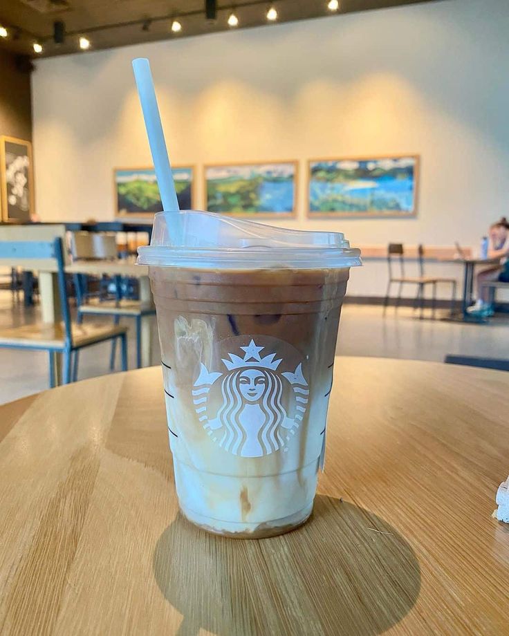 a starbucks drink sitting on top of a wooden table