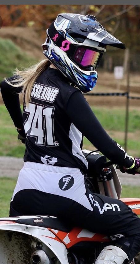 a woman riding on the back of a dirt bike