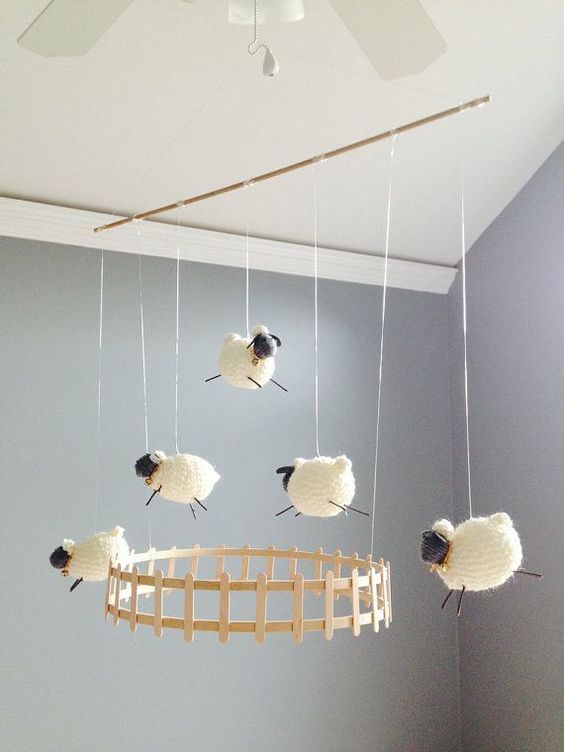 three sheep are hanging from the ceiling in a room with blue walls and white carpet