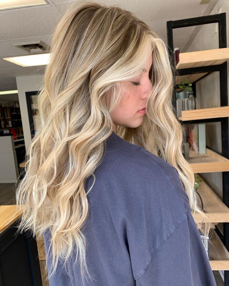 a blonde woman with long wavy hair in a salon