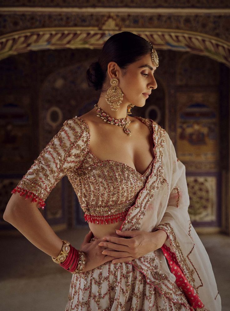 Embrace elegance in this ivory organza lehenga choli set, exquisitely embroidered with gold dabka, sequins, beadwork, and red resham French knots. It comes with a red bandhej second dupatta to add a vibrant touch. Embroidered Bridal Lehenga, Organza Lehenga, Indian Wedding Wear, Embellished Blouse, French Knots, Indian Wedding Dress, Bridal Lehenga, Bridal Couture, Modern Bride